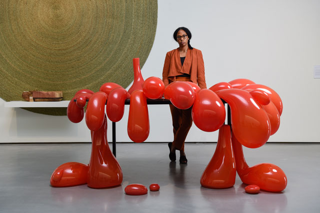 Anthea Hamilton poses in front of her work Vulcano Table, 2014. Photograph © Darren O’Brien/Guzelian. Courtesy The Hepworth Wakefield.