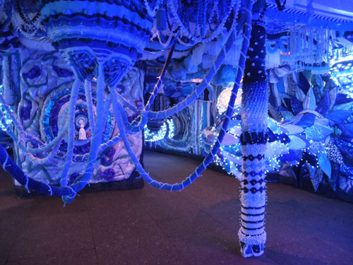 Joana Vaconselos. Decommissioned ferry, exterior covered in typical Portuguese blue and white tiles showing a Lisbon panorama. Ship's hold transformed into a fuzzy blue womb of crochet and fairy lights, with padded walls and giant pompoms hanging from above. Photograph: Dorothy Feaver.