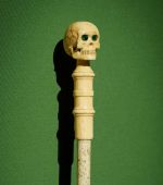 Charles Darwin's walking stick, 19th century, whalebone with skull pommel in ivory with green glass eyes.